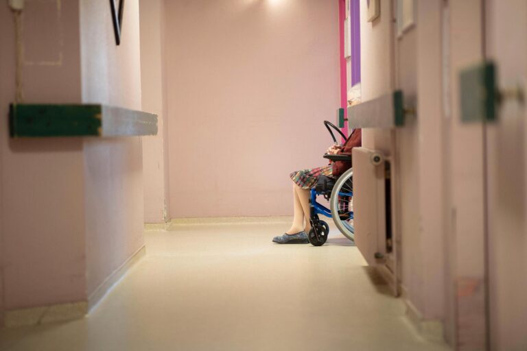 A resident is pictured using a wheelchair inside a nursing home.