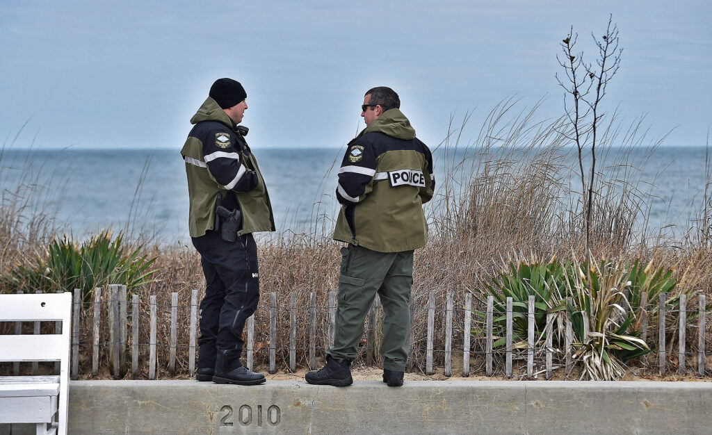2020 03 21-b comegys-delaware rehoboth beach-beaches closed coronavirus-4 Rehoboth Beach Police patrolmen stand on a wall at an empty boardwalk