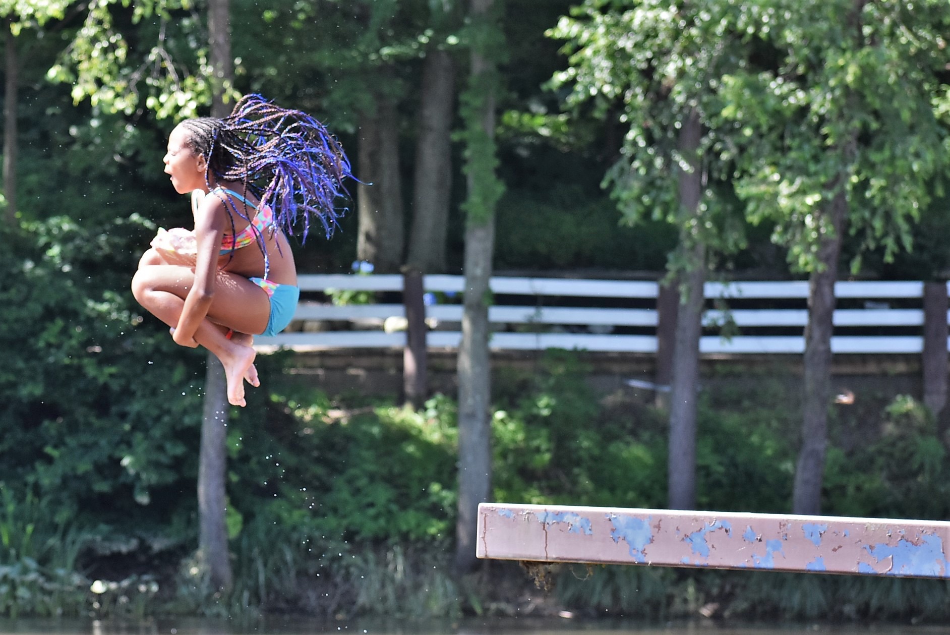 Summer camper leaps off a diving platform