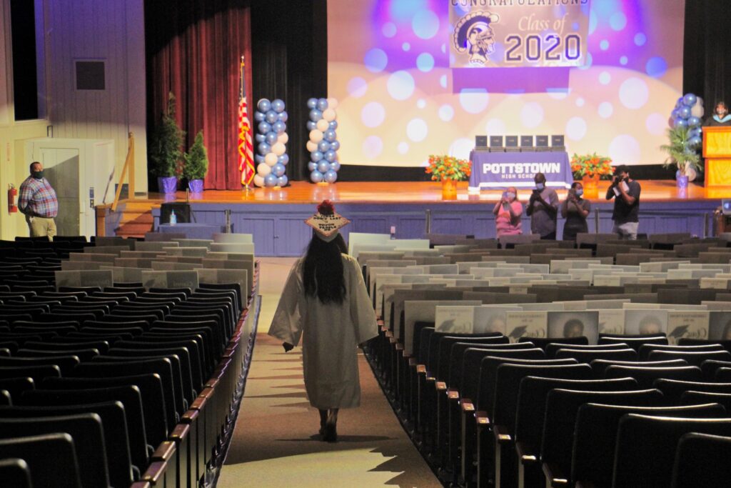 2020 05 27-e lee-melissa coleman-pottstown high school-covid graduation Melissa Coleman walks toward the stage at Pottstown High School to the sound of Pomp and Circumstance. Four members of her family were allowed to attend the mini-cermony, which was repeated for each member of the graduating class. (Emma Lee/WHYY)