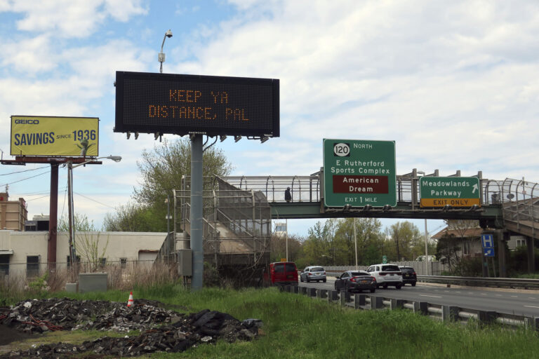 A sign reminds people to social distance during the coronavirus pandemic in Secaucus, New Jersey, on Monday, May 4, 2020. (AP Photo/Ted Shaffrey)
