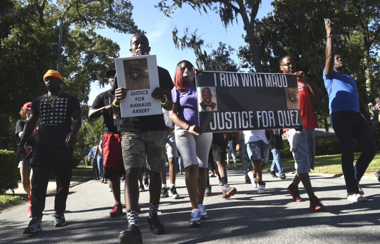 In this Tuesday, May 5, 2020, photo, a crowd marches through a neighborhood in Brunswick, Ga. They were demanding answers in the death of Ahmaud Arbery. (Bobby Haven/The Brunswick News via AP)