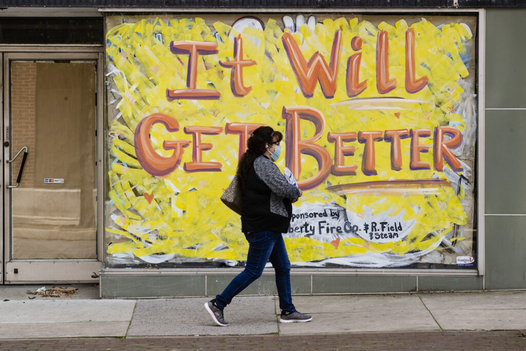 Virus Outbreak Pennsylvania A person wearing a protective face mask as a precaution against the coronavirus walks by a closed storefront in Lebanon, Pa., Tuesday, May 12, 2020. (AP Photo/Matt Rourke)