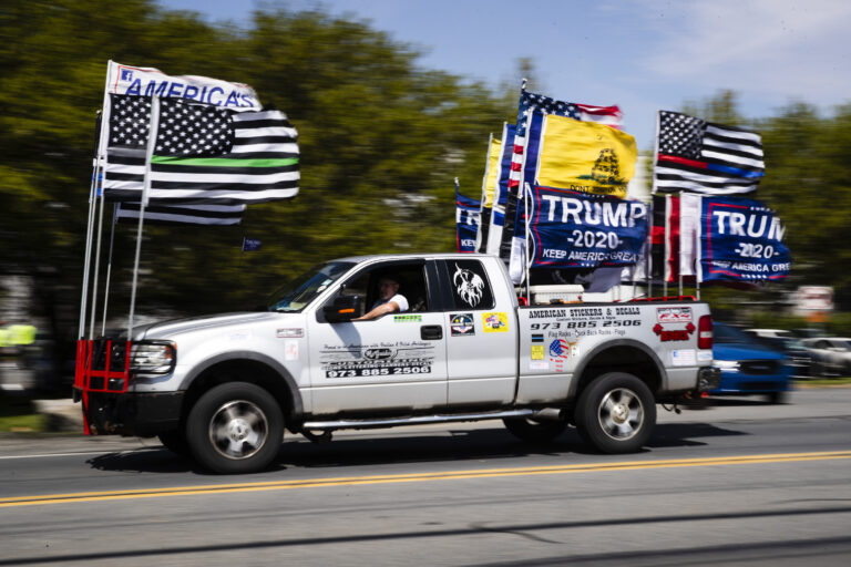 A man drives a truck decorated with flags ahead of President Donald Trump's scheduled visit at Owens and Minor warehouse in Allentown, Pa., Thursday, May 14, 2020. (AP Photo/Matt Rourke)