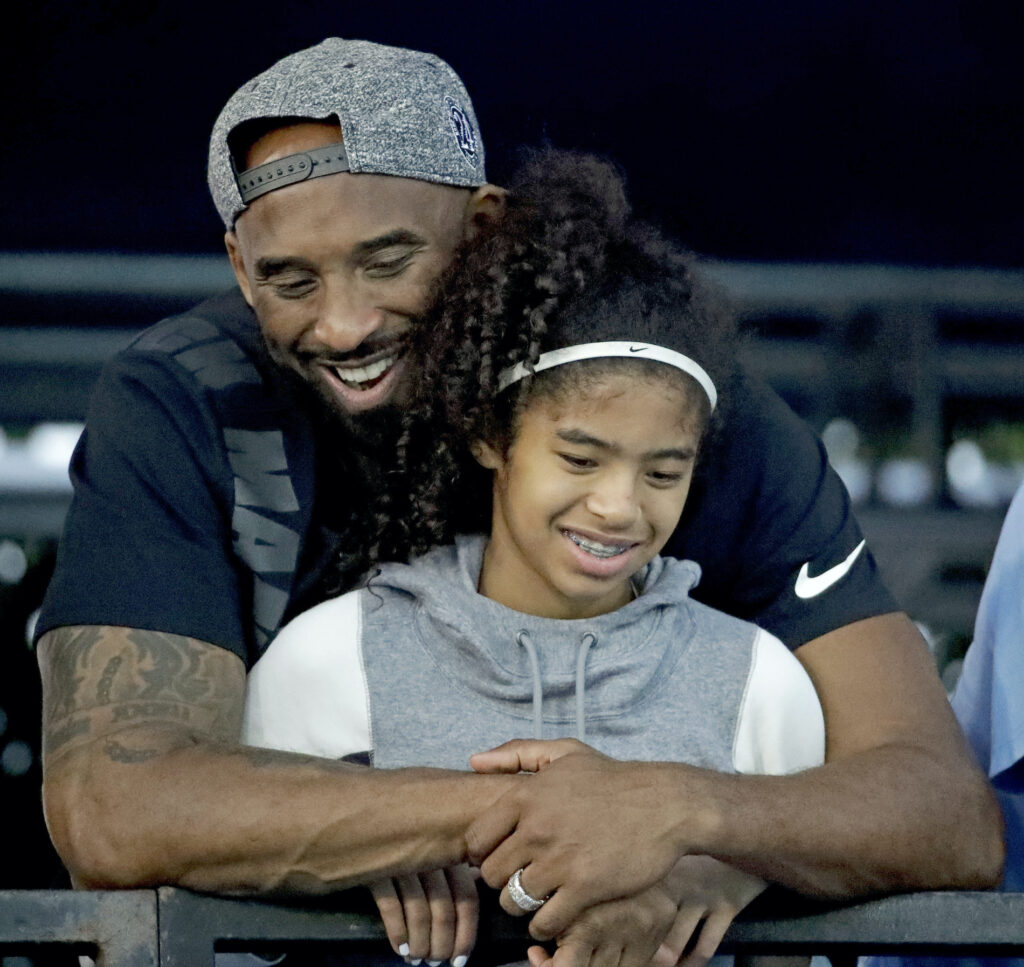 Kobe Bryant and his daughter Gianna watch during the U.S. national championships swimming meet