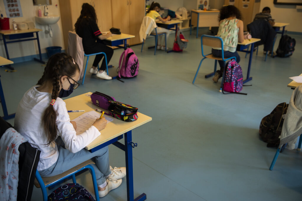 Students, wearing face masks and paying attention to social distancing, study at Les Magnolias primary school during the partial lifting of coronavirus, COVID-19, lockdown regulations in Brussels, Monday, May 18, 2020. (AP Photo/Francisco Seco)