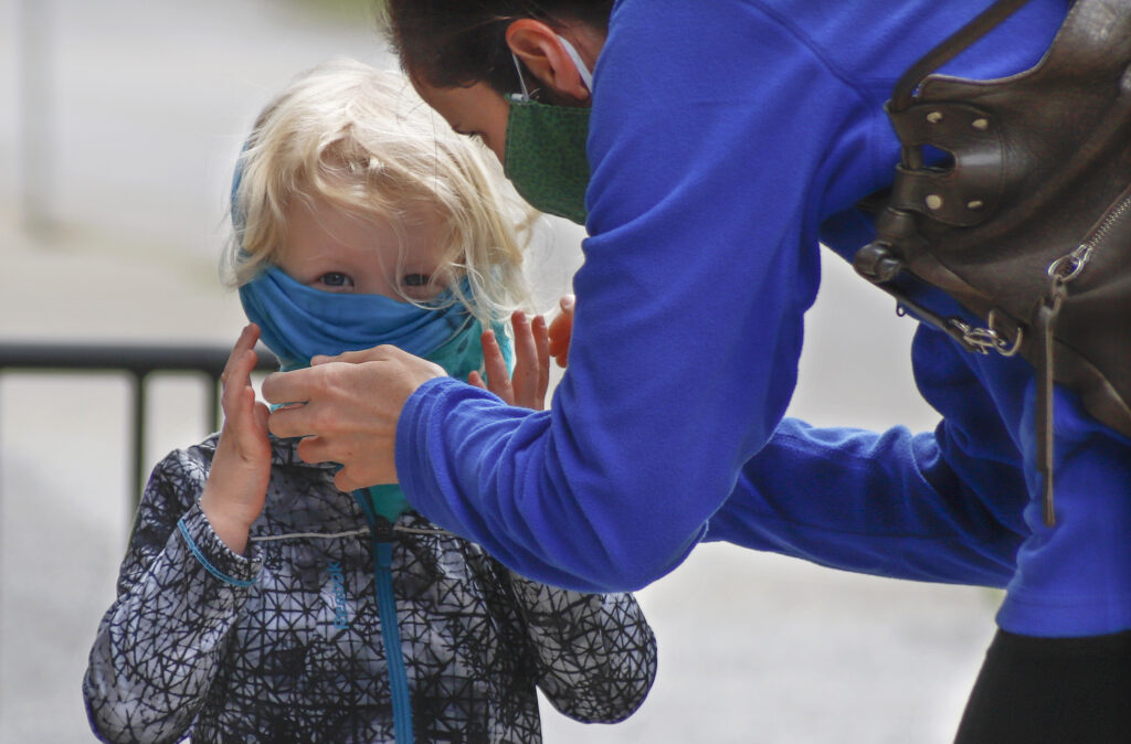 Virus Outbreak Pennsylvania Daily Life Bridget Kreider, right, helps her three-year-old daughter Maggie pull on her protective face covering before entering a store, Wednesday, May 20, 2020, in Harmony, Pa. Customers entering stores are required to wear face coverings to help prevent the spread of the new coronavirus during the COVID-19 pandemic under the state yellow phase reopening guide. (AP Photo/Keith Srakocic)