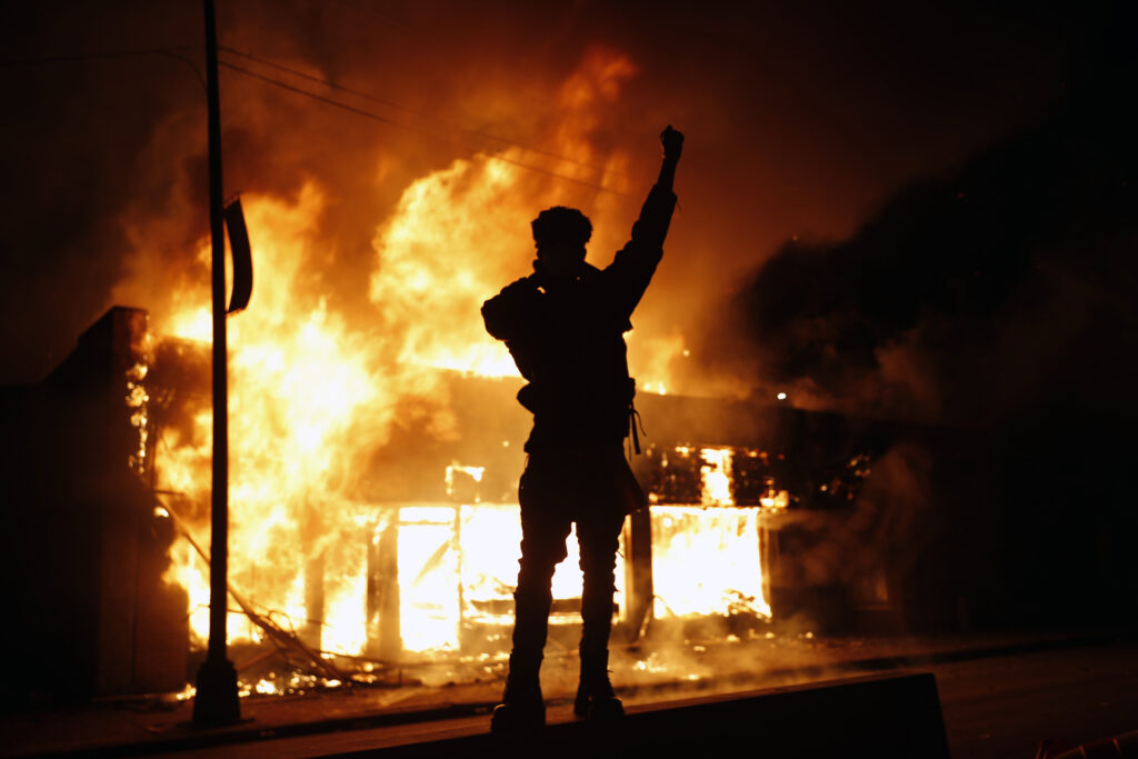 In this May 29, 2020, photo, a check-cashing business burns during protests in Minneapolis. (AP Photo/John Minchillo)