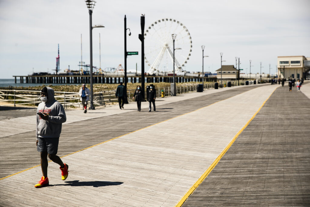 Virus Outbreak Misinformation States Person wears mask while walking Atlantic City boardwalk