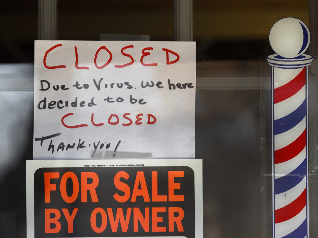“For Sale By Owner” and “Closed Due to Virus” signs are displayed in the window of Images On Mack in Grosse Pointe Woods, Mich. Congress is considering ways to help those struggling during the economic downturn and stabilize businesses hoping to reopen.