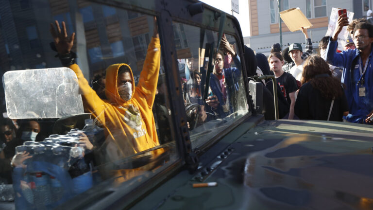 A National Guard vehicle reflects a crowd of protesters Friday in Minneapolis, where Maj. Gen. Jon Jensen said that night's deployment 