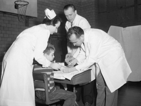 Jonas Salk administers a vaccine to a child