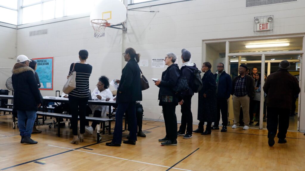People stand in line at a Detroit polling place during Michigan’s March 10 presidential primary. Because of the pandemic, the state’s top election official is sending absentee ballot applications to every registered voter for August and November elections. People stand in line at a Detroit polling place during Michigan's March 10 presidential primary. Because of the pandemic, the state's top election official is sending absentee ballot applications to every registered voter for August and November elections. (Jeff Kowalsky/AFP via Getty Images)