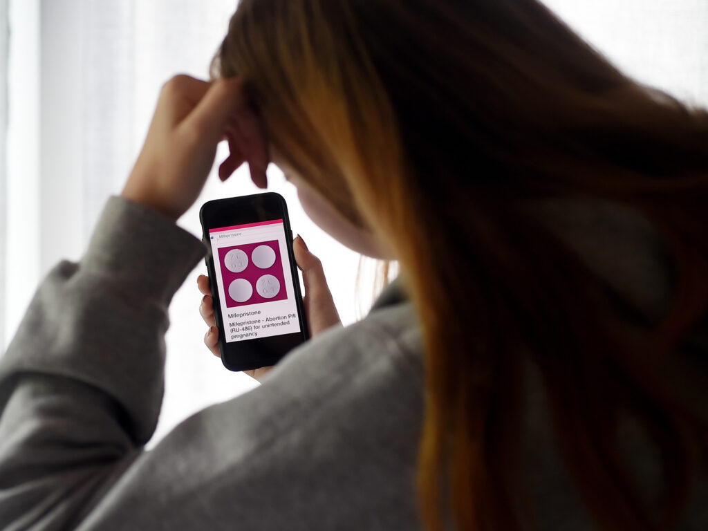 In this photo illustration, a person looks at an abortion pill (RU-486) for unintended pregnancy from Mifepristone displayed on a smartphone on May 8, 2020, in Arlington, Va. Under federal law, even in states where telemedicine abortion is legal, there are strict rules surrounding how the pill is dispensed. In this photo illustration, a person looks at an abortion pill (RU-486) for unintended pregnancy from Mifepristone displayed on a smartphone on May 8, 2020, in Arlington, Va. Under federal law, even in states where telemedicine abortion is legal, there are strict rules surrounding how the pill is dispensed. (Olivier Douliery/AFP via Getty Images)