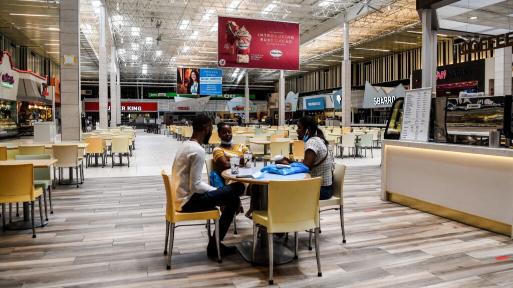 People eat in a deserted food court inside a mall west of Fort Lauderdale, Fla., Monday. U.S. states have been easing restrictions on businesses ahead of Memorial Day, the traditional start of the summer vacation and outdoor season. People eat in a deserted food court inside a mall west of Fort Lauderdale, Fla., Monday. U.S. states have been easing restrictions on businesses ahead of Memorial Day, the traditional start of the summer vacation and outdoor season. (Chandan Khanna/AFP via Getty Images)