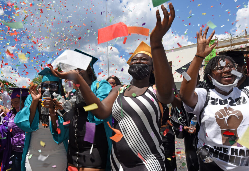 01-2 (1) At Farnham Park on June 26, Camden High graduate Zanabria Harris, 18, stands in a sea of confetti at the end of the parade. (Photo by April Saul for WHYY)