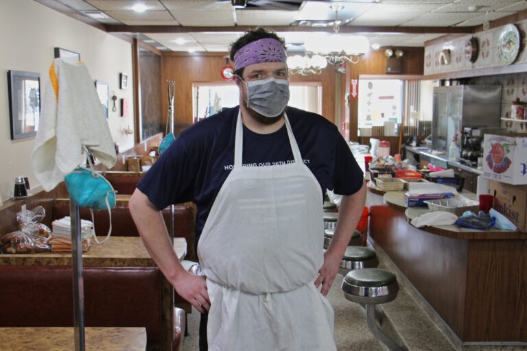 Chad Todd stands in the dining room at Sulimay's restaurant, which has become a staging area. (Emma Lee/WHYY)