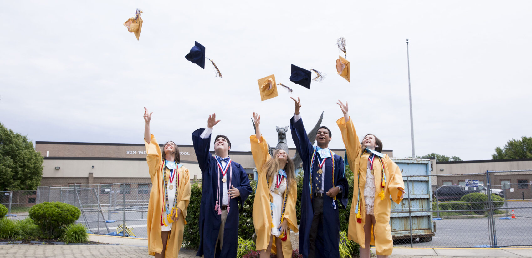 Bryson Eldridge (second to right), senior class president at his school, throws his graduation cap with other class officers after a segment they recorded for virtual graduation. Sun Valley High, in the Penn-Delco School District, is about 80% white.  (Rachel Wisniewski for Keystone Crossroads)
