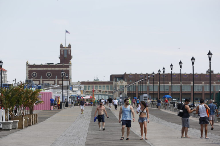 People walk along the boardwalk in Asbury Park, N.J., Wednesday, June 21, 2017. (AP Photo/Seth Wenig)