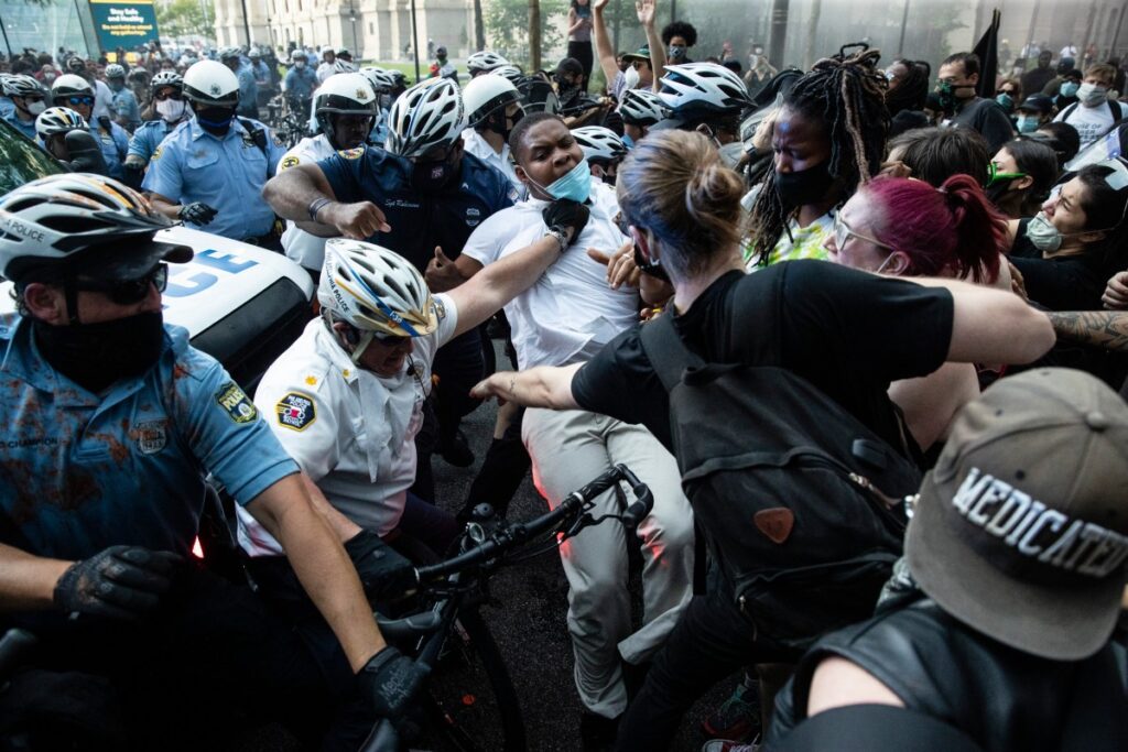 AP_20152131211906 (1) Police and protesters clash Saturday, May 30, 2020, in Philadelphia, during a demonstration over the death of George Floyd. Protests were held throughout the country over the death of Floyd, a black man who died after being restrained by Minneapolis police officers on May 25. (AP Photo/Matt Rourke)