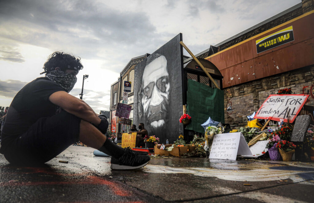 APTOPIX America Protests Minneapolis Trevor Rodriquez sits alone at the spot where Floyd died at the hands of police
