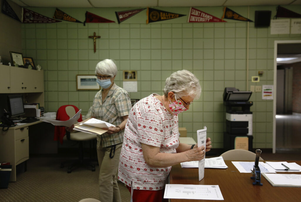 Virus Outbreak Catholic School Closures Guidance secretary Marge Berckmiller, left, and Sister Bridget Reilly, director of guidance, prepare student transcripts to send to other schools after the closure of Quigley Catholic High School in Baden, Pa., Monday, June 8, 2020. (AP Photo/ Jessie Wardarski)