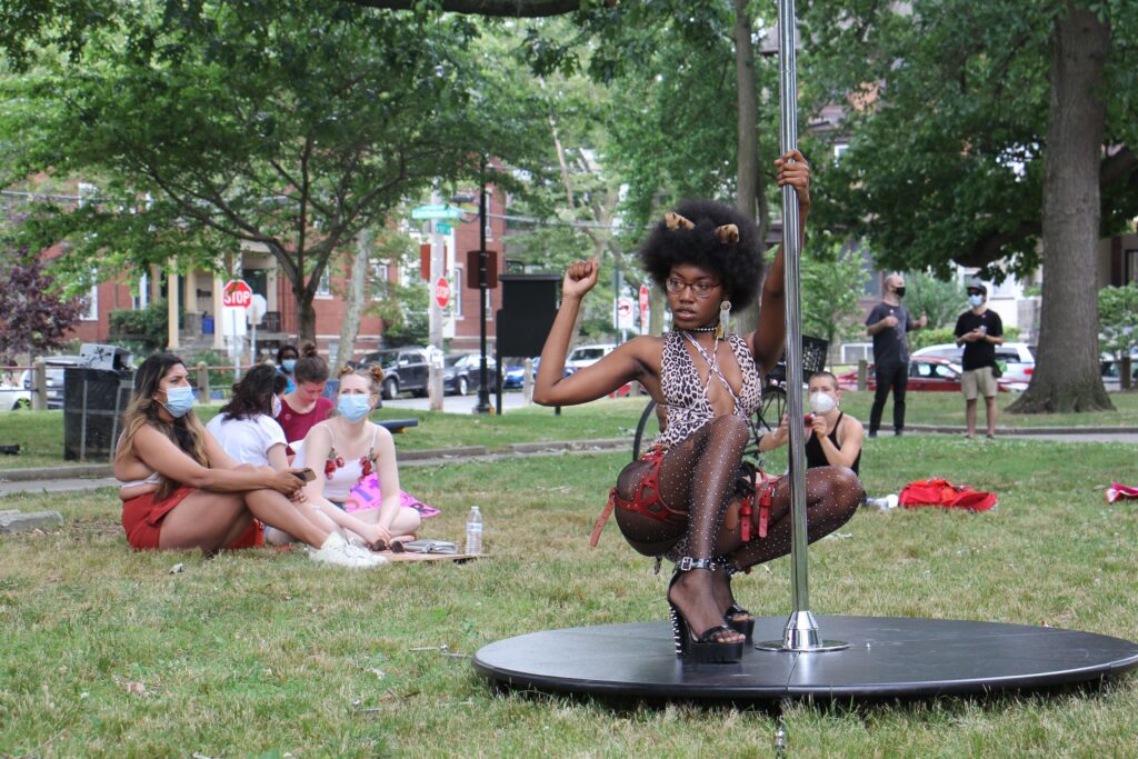 Image from iOS (100) A dancer known by the professional name Tabz poses with a dance pole at Malcolm X Park. She is a leader of the group Stiletto, which held an event in the park to advocate for better working conditions for dancers and sex workers. (Emma Lee/WHYY)
