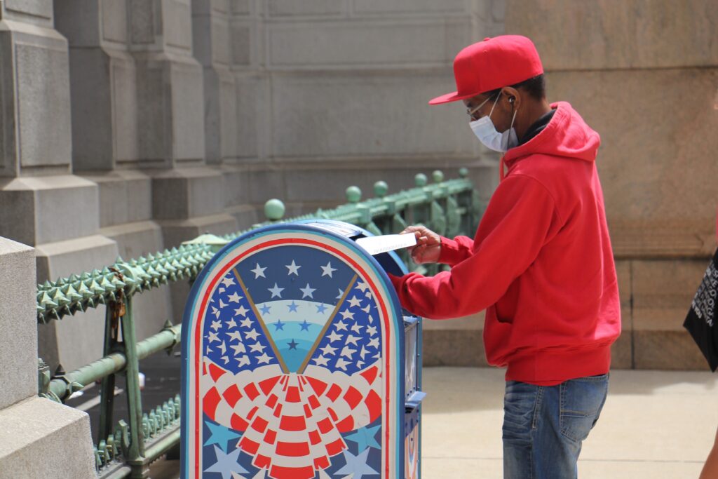 Odell Griffin places his mail-in ballot in a box outside City Hall.