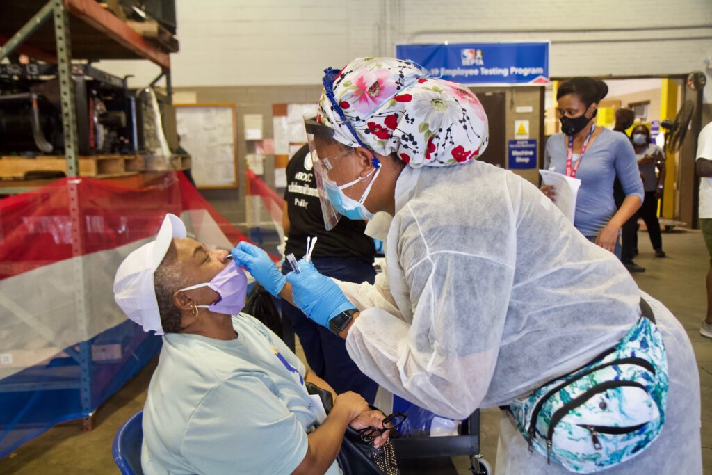 Image from iOS Sharon Settles, a maintenance worker, is tested for COVID-19 by Registered Nurse Cyndi Walker of the Black Doctors COVID-19 Consortium at the Fern Rock Transportation Center in Philadelphia. (Kimberly Paynter/WHYY)