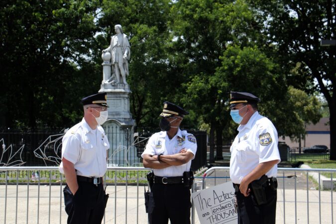 In mid-June, Philadelphia police maintained a presence at the statue of Christopher Columbus at Broad and Oregon in South Philadelphia. Some Italian Americans who see the statue as part of their heritage have turned out to guard the statue, raising the possibility of conflict with those who see it as a symbol of genocide. (Emma Lee/WHYY)