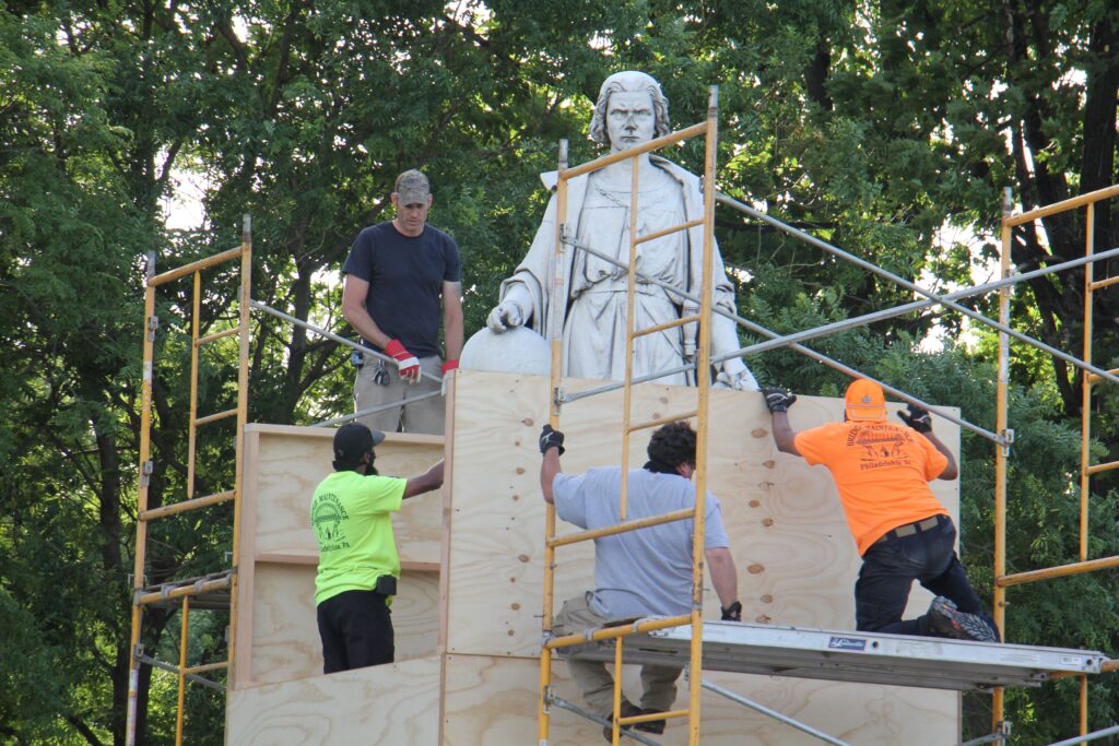 Image from iOS (76) Workers box up the statue of Christopher Columbus in Marconi Plaza. (Emma Lee/WHYY)
