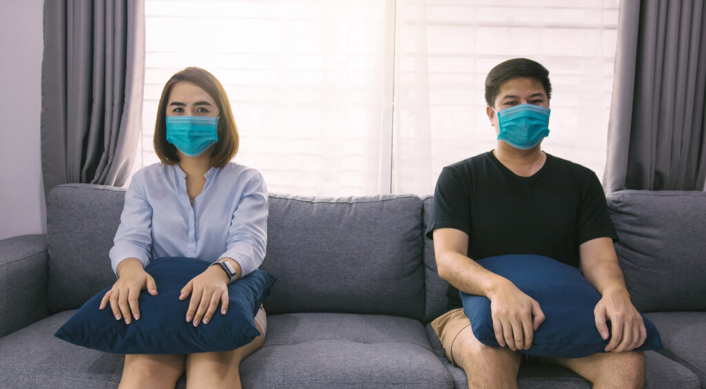 Two Asian Couple Lovers Sit On The Sofa At Home Spaced Apart Fro Relationships during the pandemic