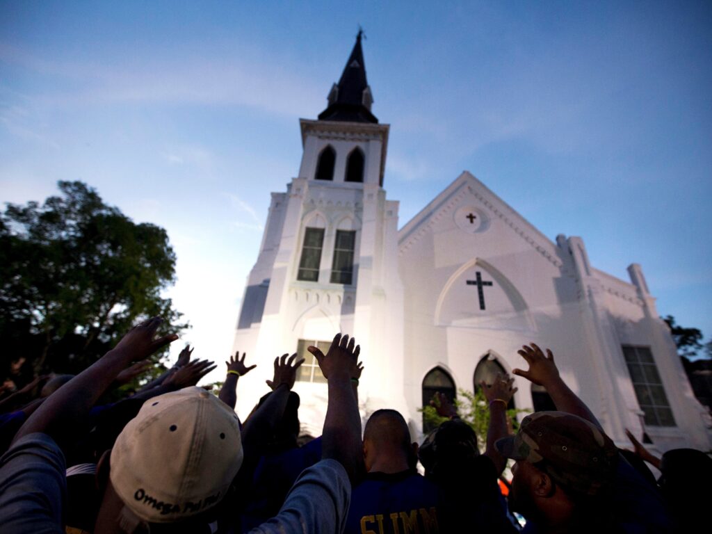In this June 19, 2015, file photo, the men of Omega Psi Phi Fraternity Inc. lead a crowd of people in prayer outside the Emanuel AME Church, after a memorial service for the nine people killed by Dylann Roof in Charleston, S.C. In this June 19, 2015, file photo, the men of Omega Psi Phi Fraternity Inc. lead a crowd of people in prayer outside the Emanuel AME Church, after a memorial service for the nine people killed by Dylann Roof in Charleston, S.C. (Stephen B. Morton/AP)