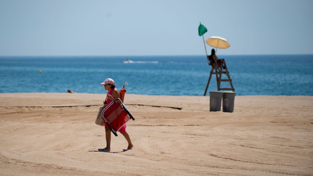 A woman walks past a lifeguard on a beach in Lloret de Mar this week, as beaches in Spain reopen following a lockdown to stop the spread of the coronavirus. The EU is now considering which countries should be allowed to send tourists to its member nations. A woman walks past a lifeguard on a beach in Lloret de Mar this week, as beaches in Spain reopen following a lockdown to stop the spread of the coronavirus. The EU is now considering which countries should be allowed to send tourists to its member nations.