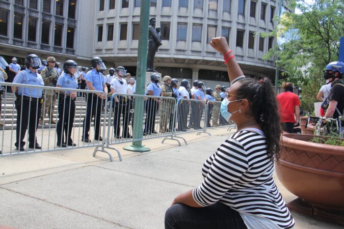 A protester kneels in front of Philadelphia police headquarters