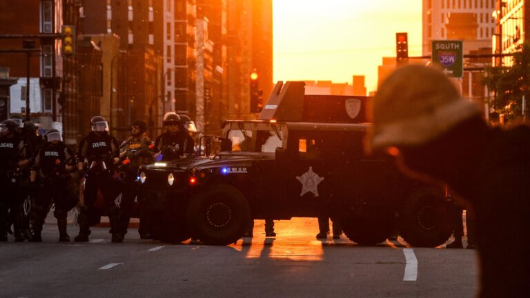 Police officers take guard during a protest over the death of George Floyd last month in Minneapolis.