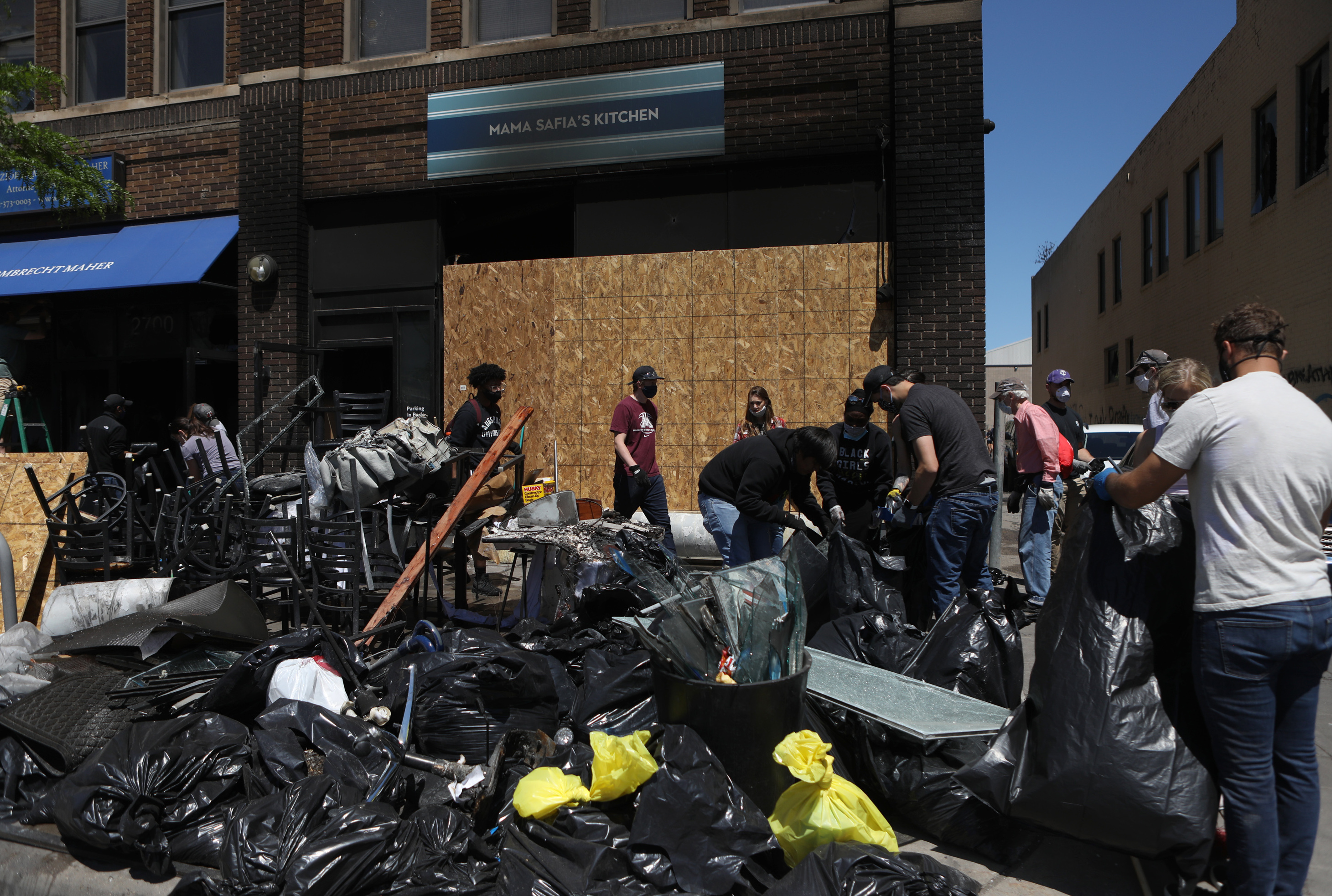 Volunteers clear debris from Mama Safia's Kitchen. Dozens of volunteers from across Minneapolis came to help.