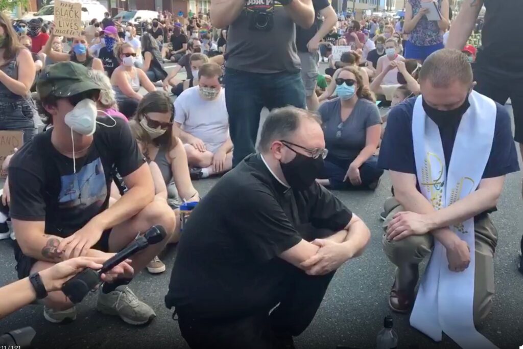 rev Two members of clergy who are not with POWER say a prayer in Fishtown. (Katie Meyer/WHYY)