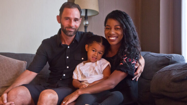 Aria Valentina Riso in between her mom, Chelsie DeSouza and dad, Vincent Riso at their home in South Philadelphia. (Kimberly Paynter/WHYY)