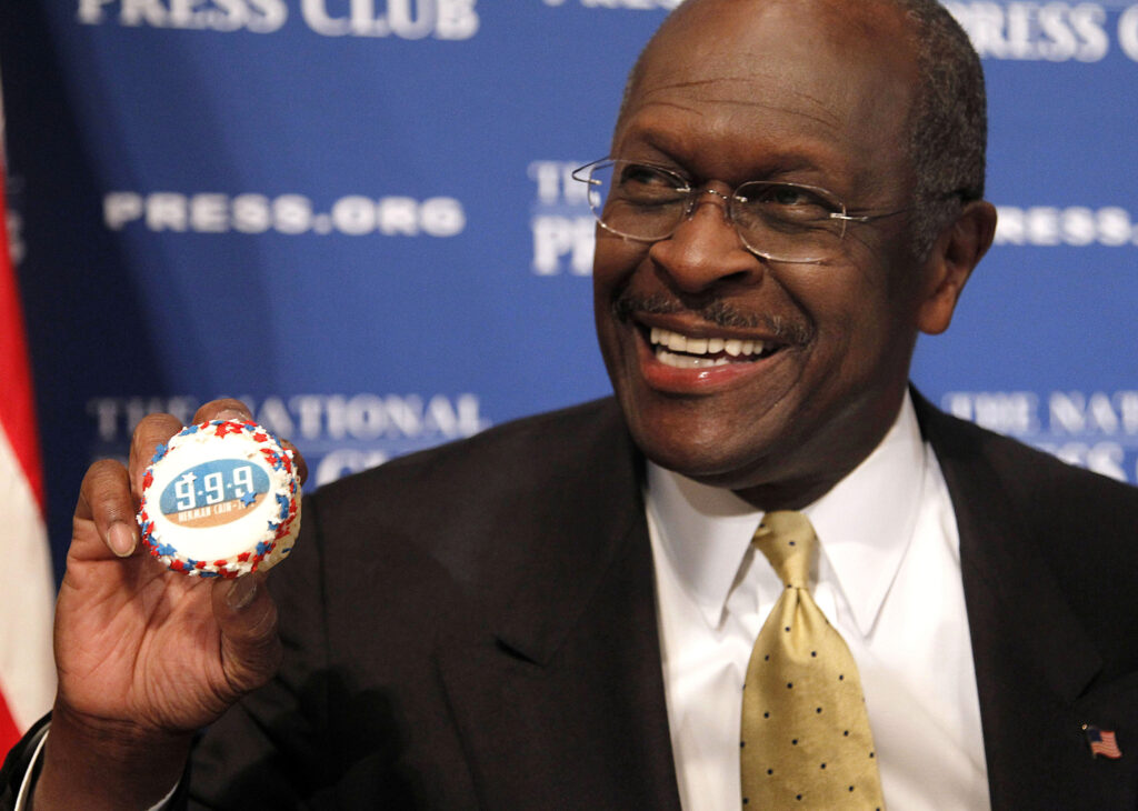Herman Cain In this Oct. 31, 2011 file photo, then-Republican presidential candidate Herman Cain holds up a muffin that has his catch-phrase 9-9-9 tax plan printed on it before speaking at the National Press Club in Washington. (AP Photo/Pablo Martinez Monsivais)