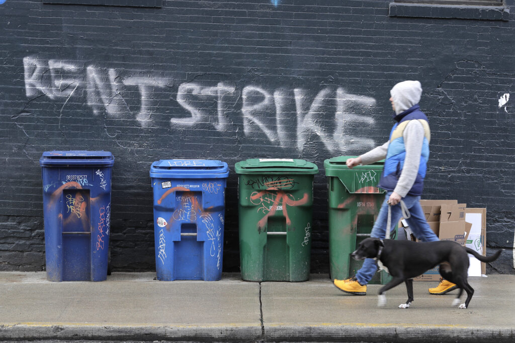 Virus Outbreak Washington State A pedestrian walks past graffiti that reads