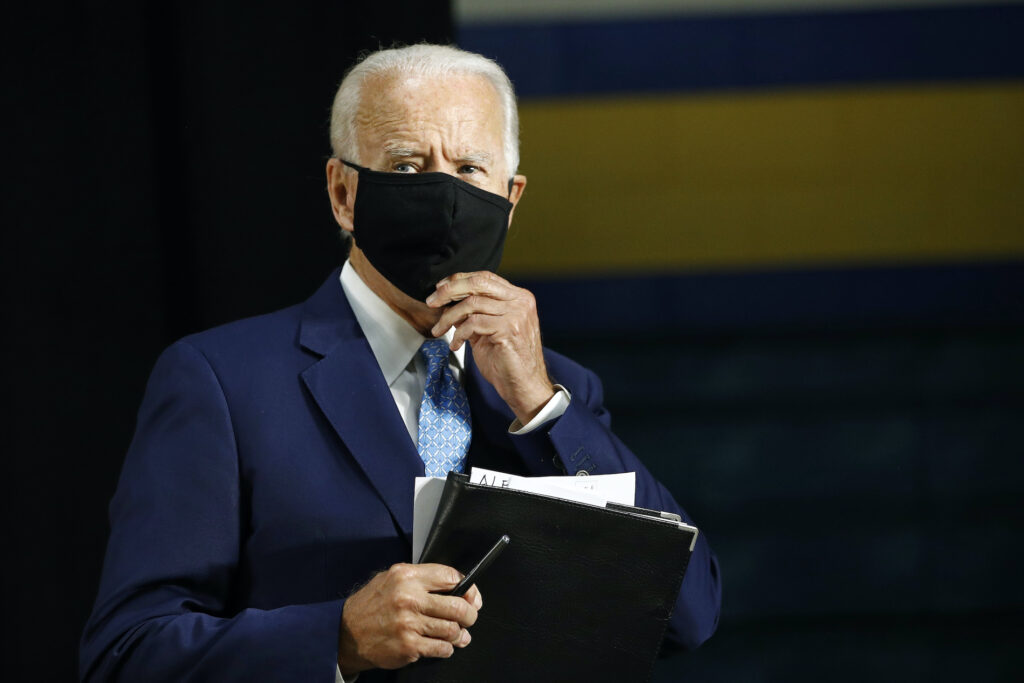 Joe Biden Democratic presidential candidate, former Vice President Joe Biden puts on a face mask to protect against the spread of the new coronavirus as he departs after speaking at Alexis Dupont High School in Wilmington, Del., Tuesday, June 30, 2020. (AP Photo/Patrick Semansky)