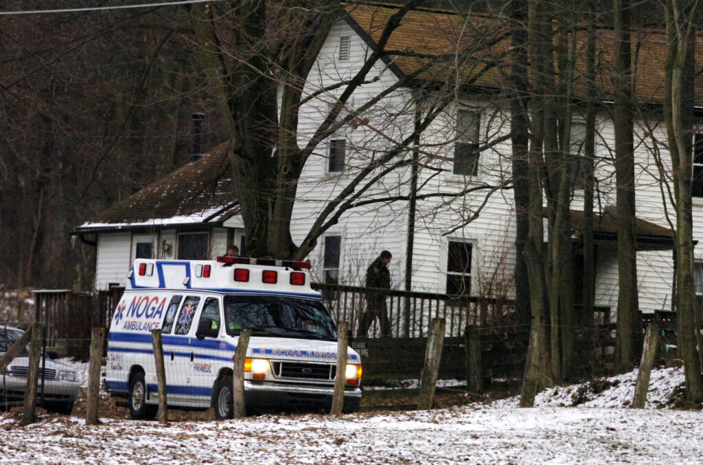 Pregnant Woman Murdered-Lawsuit FILE - In this file photo from Feb. 21, 2009, an ambulance is parked outside the farmhouse where Kenzie Marie Houk was killed in Wampum, Pa. Jordan Brown, who was eleven-years-old at the time was charged in the shooting death of the 26-year-old pregnant mother of two. He is now filing a wrongful prosecution and conviction lawsuit, alleging that the state police investigators knowingly disobeyed protocols, fabricated and manipulated evidence to further a fake narrative that he was guilty. (AP Photo/Beaver County Times, Kevin Lorenzi, File)