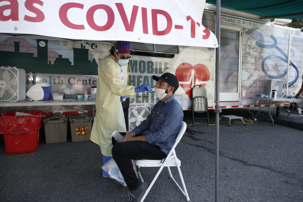 Virus Outbreak Massachusetts Nurse Tanya Markos administers a coronavirus test on patient Ricardo Sojuel at a mobile COVID-19 testing unit, Thursday, July 2, 2020, in Lawrence, Mass. (AP Photo/Elise Amendola)