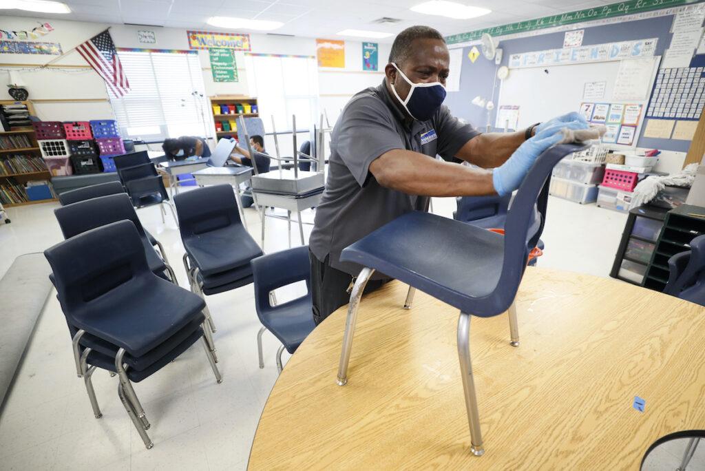Virus Outbreak Custodian Tracy Harris cleans chairs in a classroom at Brubaker Elementary School, Wednesday, July 8, 2020, in Des Moines, Iowa. (AP Photo/Charlie Neibergall)