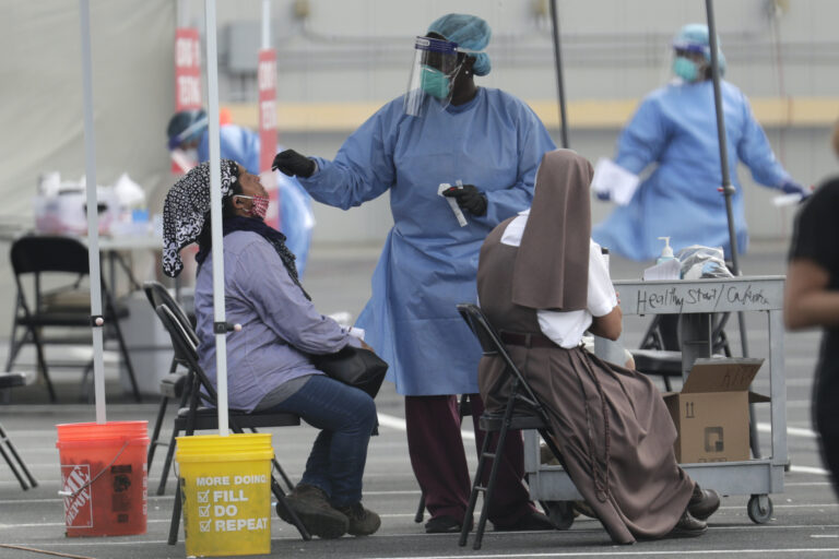 In this Monday, July 6, 2020 file photo, a health care worker administers a COVID-19 test at a site sponsored by Community Heath of South Florida at the Martin Luther King Jr. Clinica Campesina Health Center in Homestead, Fla. (AP Photo/Lynne Sladky)