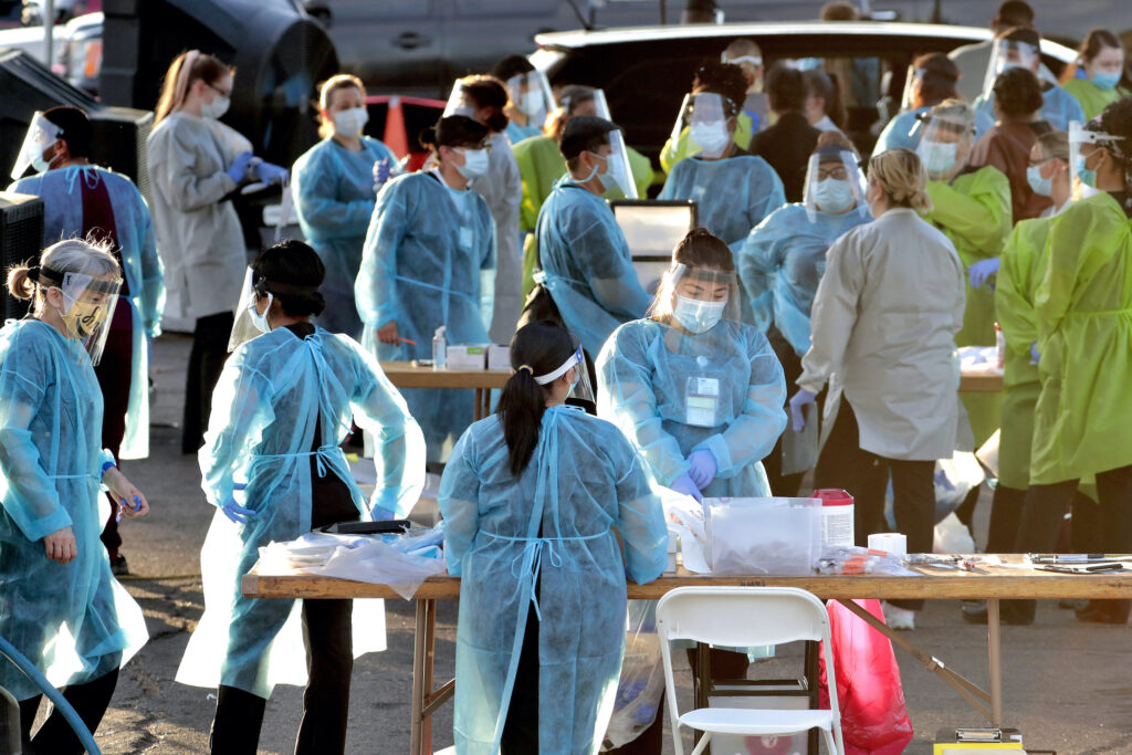 AP_coronavirus_PPE_health_workers_070720 Medical personnel prepare to test hundreds of people lined up in vehicles