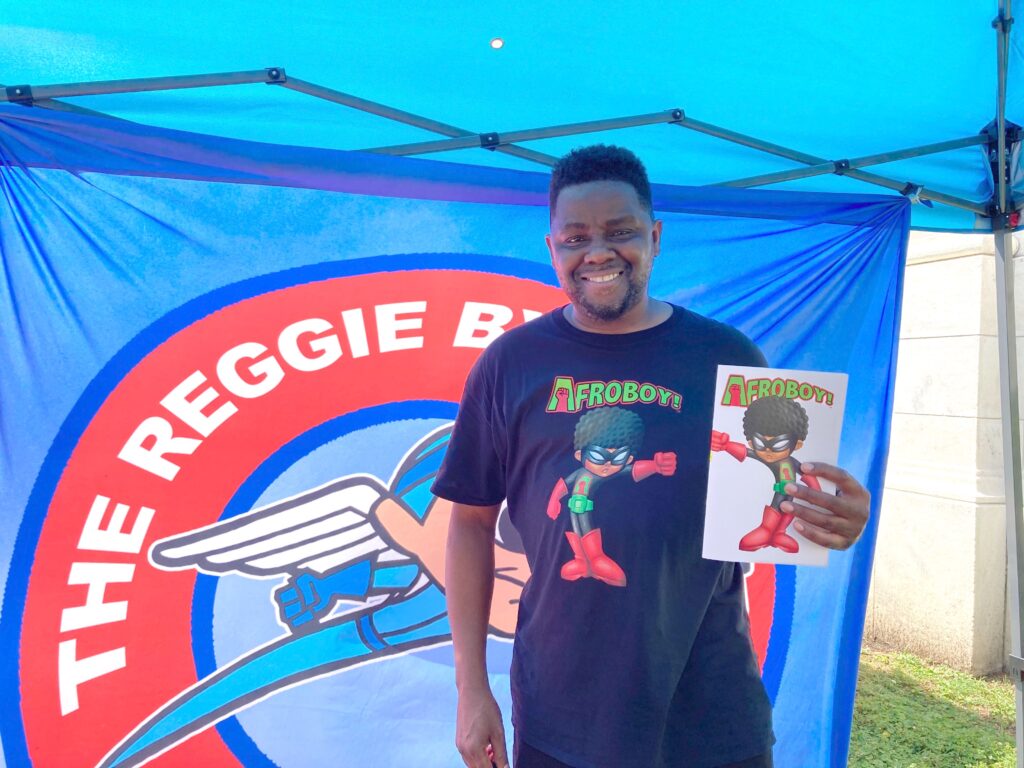 Image from iOS (112) Comic book author Reggie Byers was selling copies of his latest book, 'AFROBOY AND PUFFGIRL' at the street fair in Media. (Zachariah Hughes/WHYY)