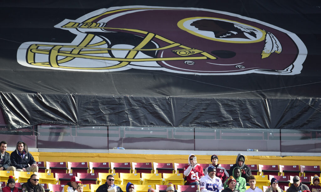 Fans sit in the stands before the start of a game between the New York Giants and Washington Redskins at FedEx Field in 2019 in Landover, Md. The Redskins, and other teams, are reviewing their names. Fans sit in the stands before the start of a game between the New York Giants and Washington Redskins at FedEx Field in 2019 in Landover, Md. The Redskins, and other teams, are reviewing their names. (Patrick McDermott/Getty Images)