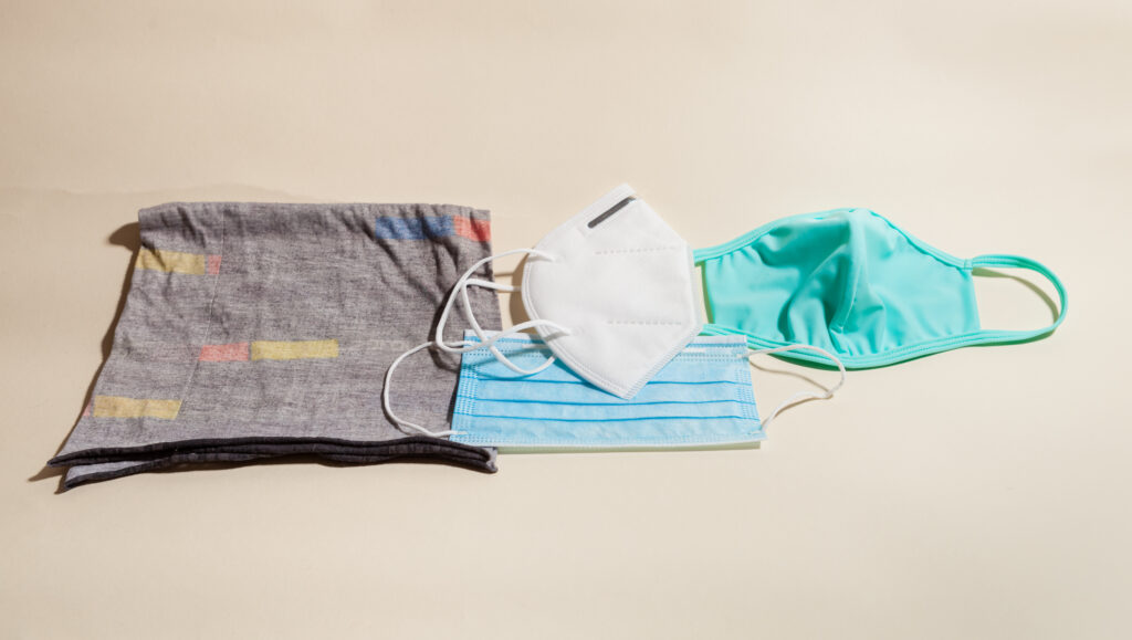 Left to right: a neck gaiter (aka a buff) that slips over the head; a KN95 respirator, a version of the N95 respirator used in U.S. hospitals; a pleated surgical mask (below the KN95); a cloth mask. Coronavirus mask